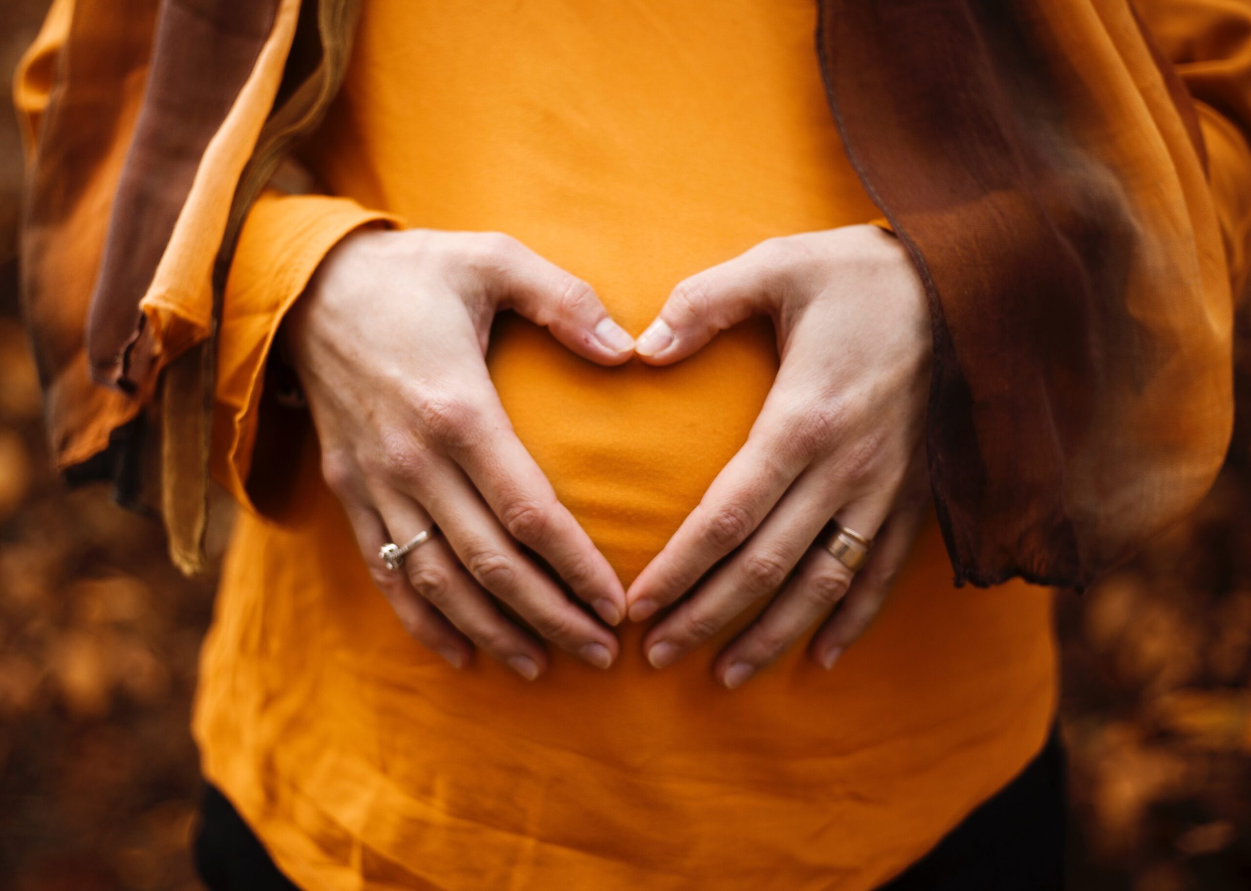 Pregnant woman making a heart over her belly